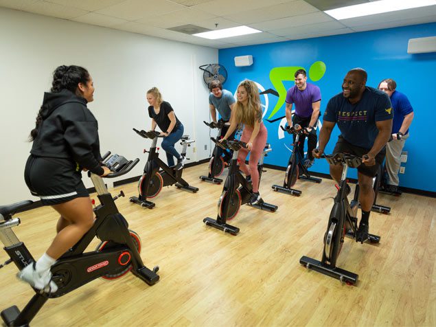 group of people working out on cardio machines in gym near me