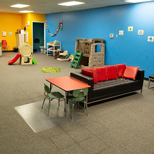 red table and couch in kids area in muvs fitness center