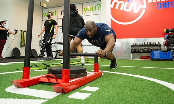 man working out on functional turf floor in gym near me