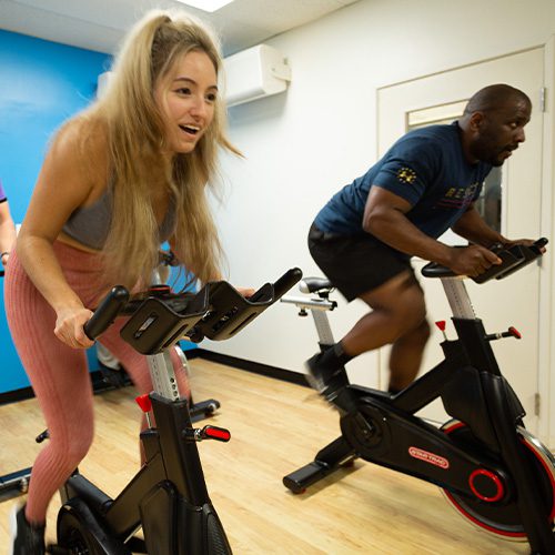 adults working out on cardio machine in gym near me