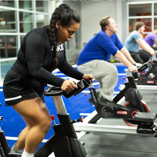 group using cardio equipment in gym