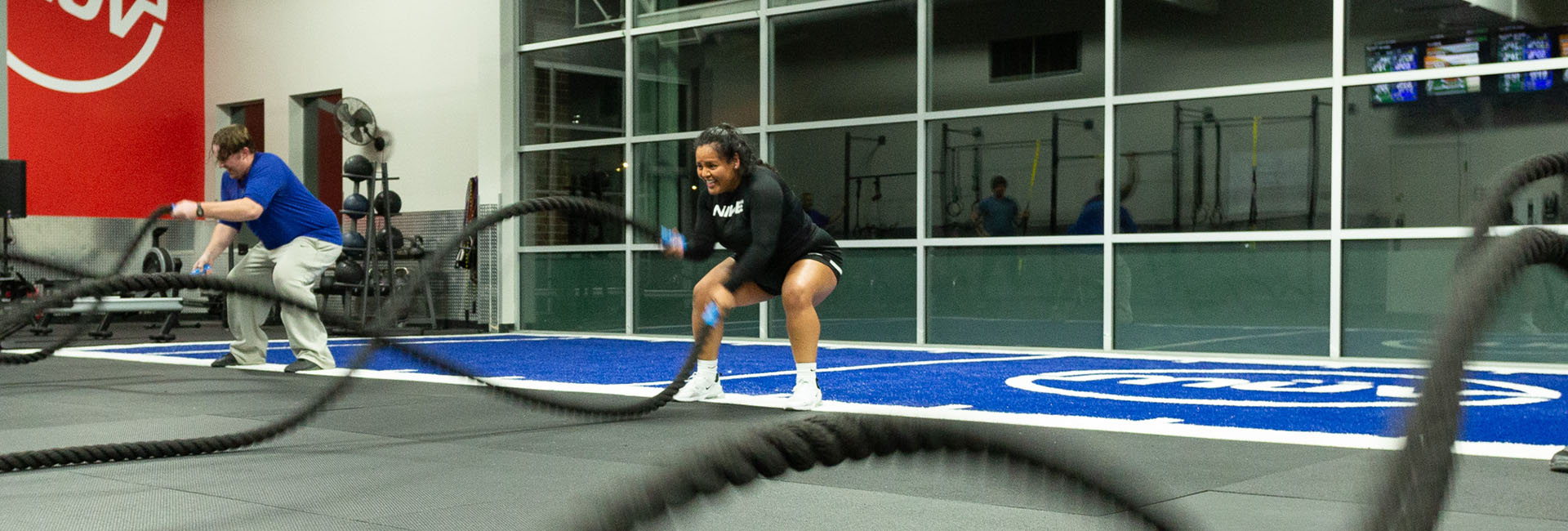 battle ropes being used by a man and woman exercising at a gym in everett