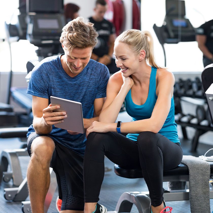 personal trainer helping a gym member