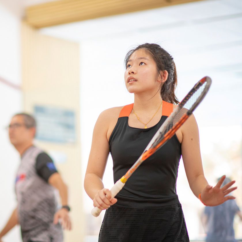 woman in a racquetball court at a fitness center