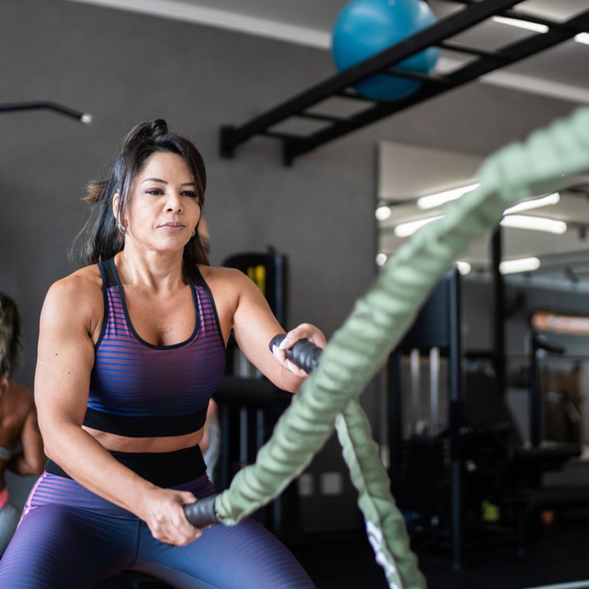 woman doing battle ropes in a gym