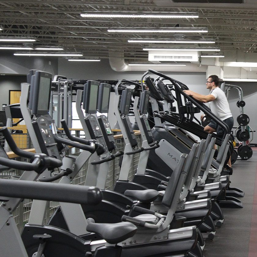 man using cardio equipment in a modern gym