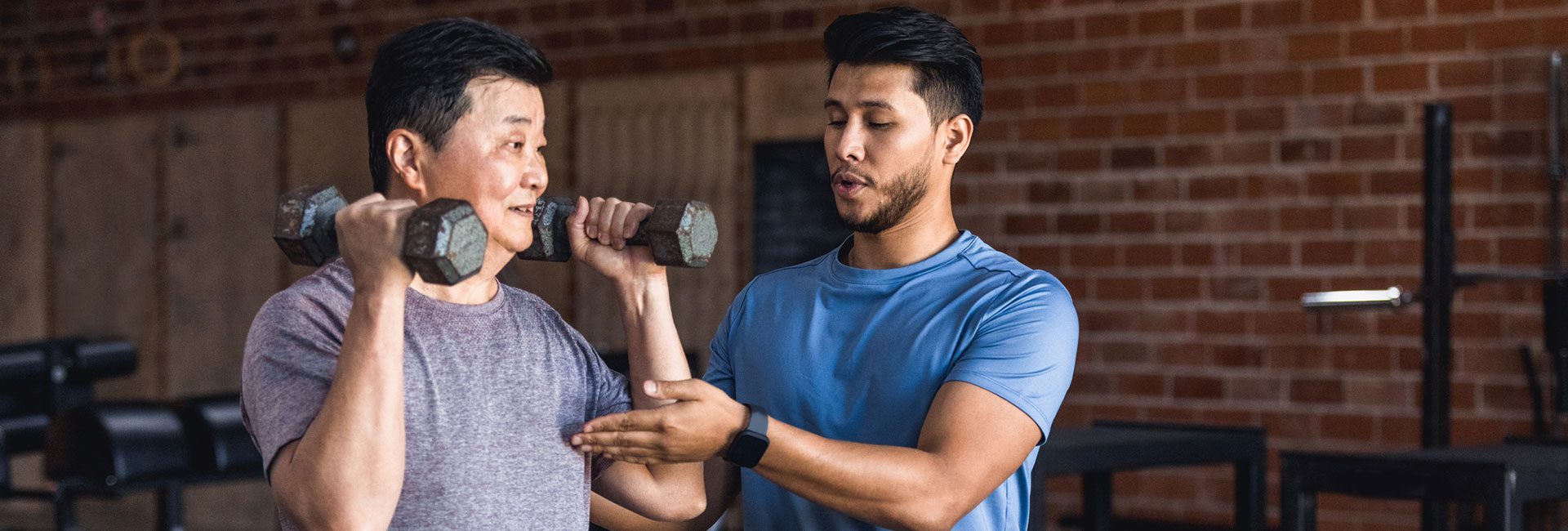 personal trainer healping a gym member workout