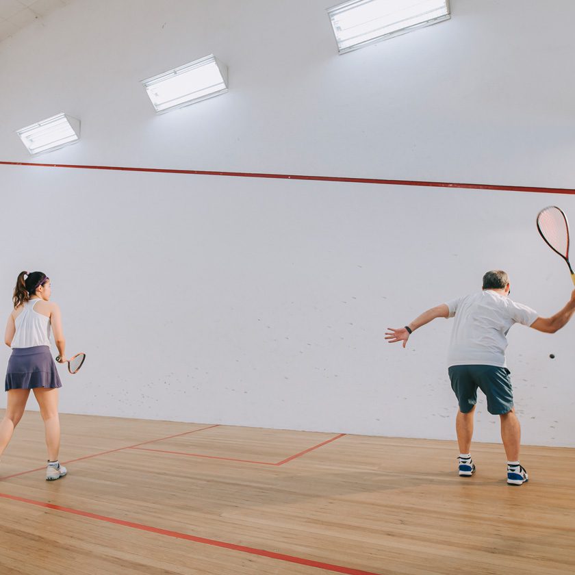 father and daughter playing racquetball at a gyms indoor court in north spokane