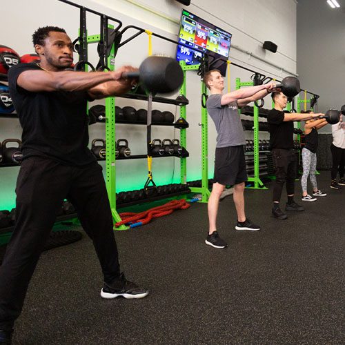 group working out with kettbells in muv fitness center