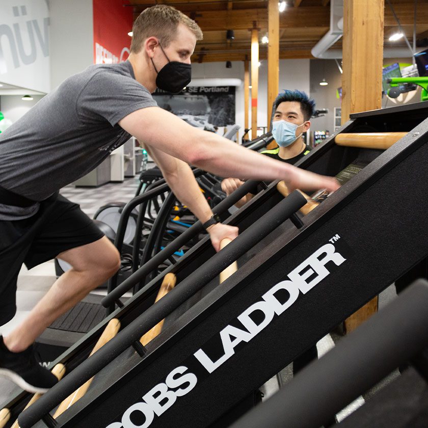 man climbing ladder machine in gym