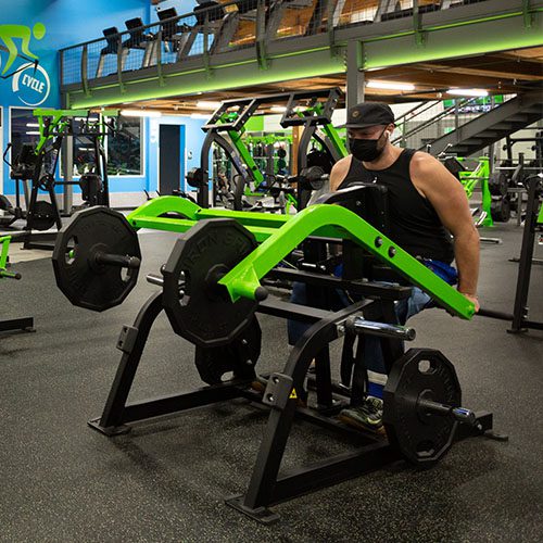 man training with weight machine in gym