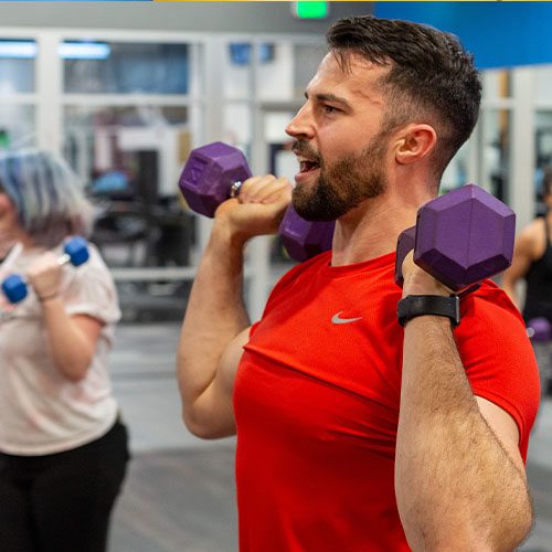 man lifting weights in a group fitness-class