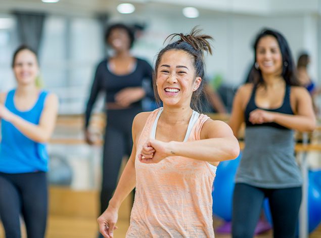 happy people dancing in exercise class