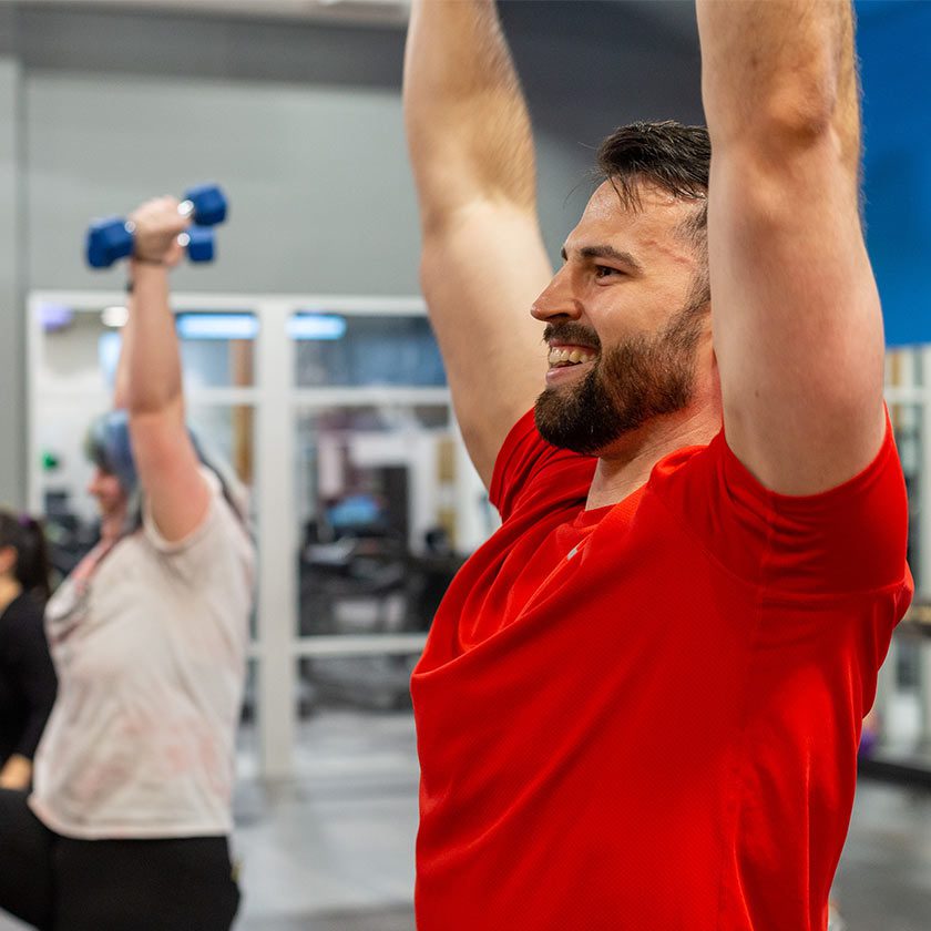 man lifting weights above head