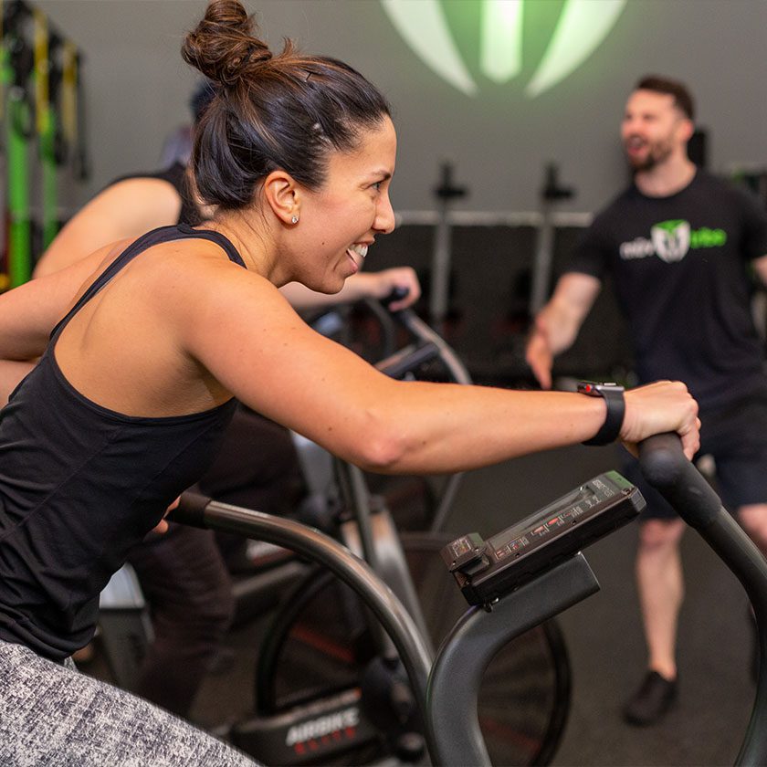 woman working out in modern gym with personal trainers