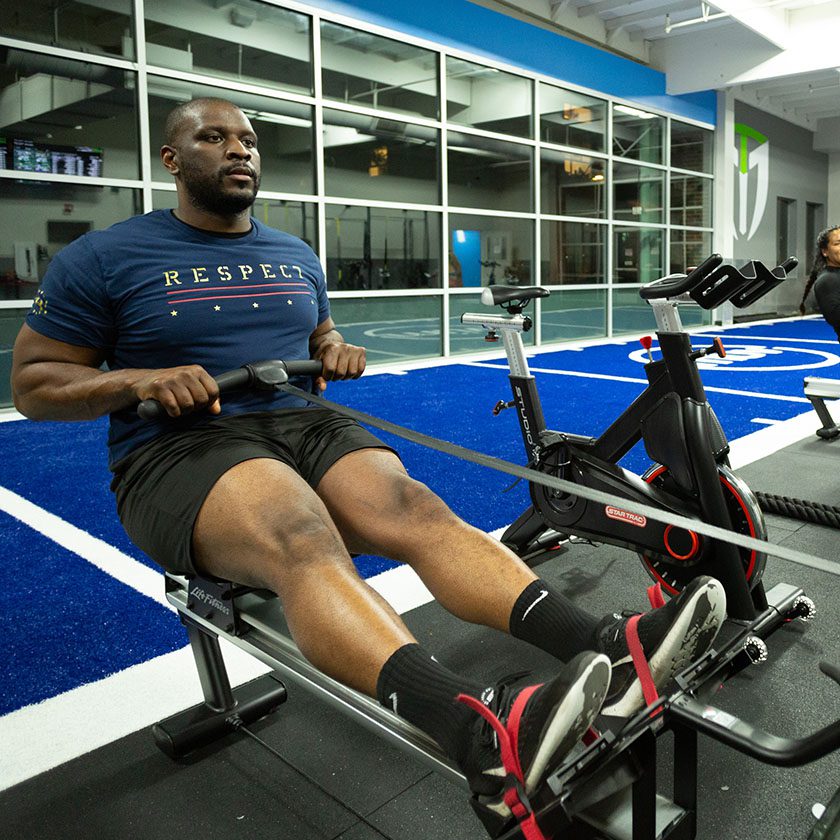 man using row machine in modern gym near me