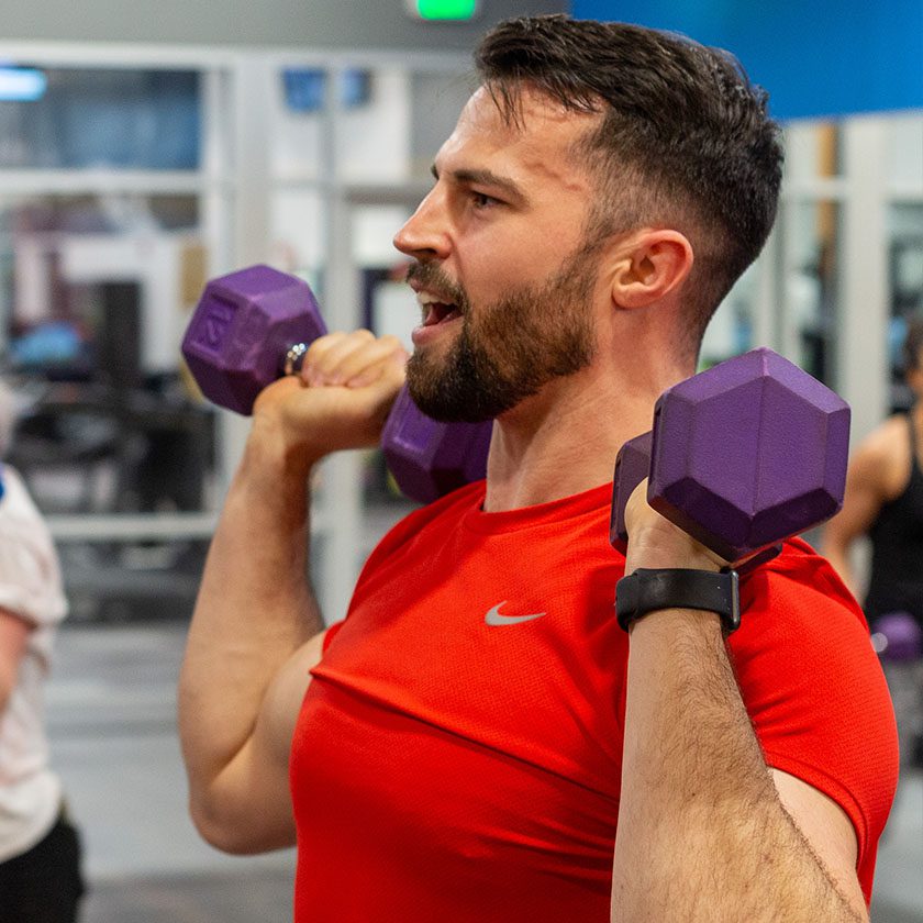 man lifting dumbbells in best gym near me